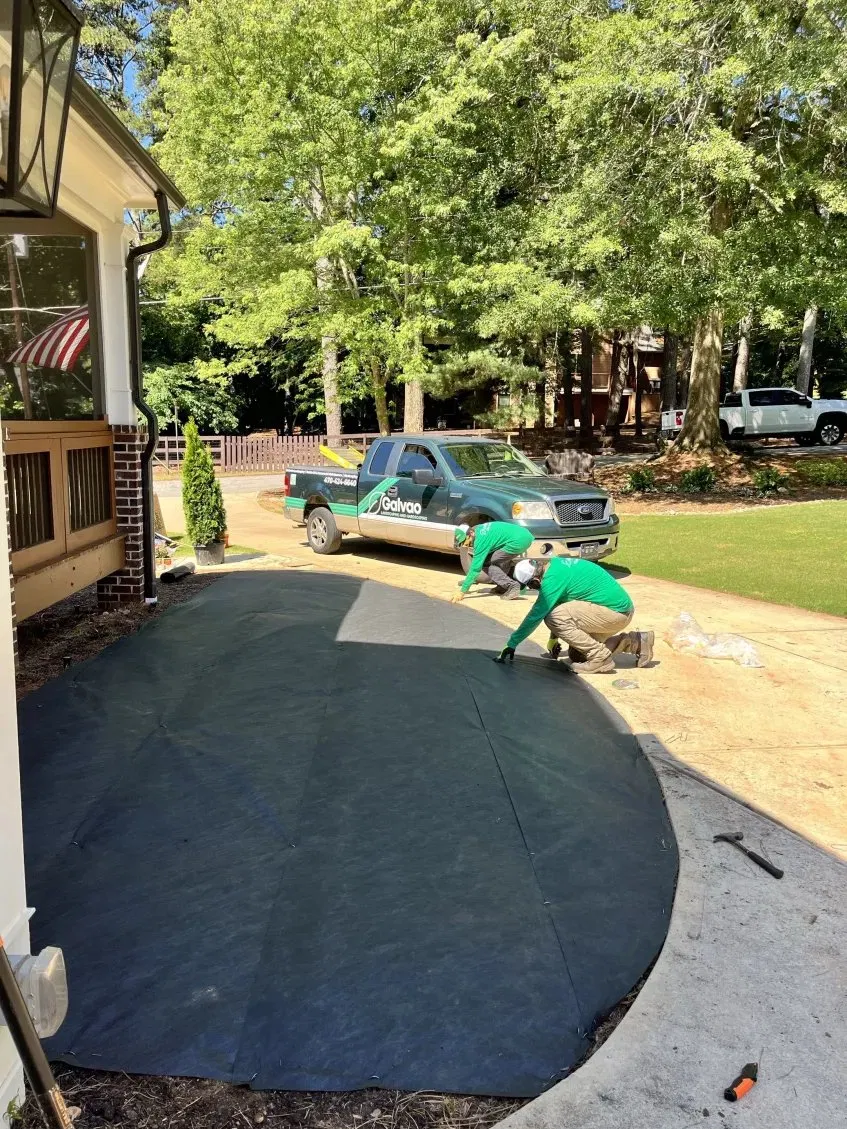 Galvao crew laying landscape fabric for a paver patio install in Atlanta